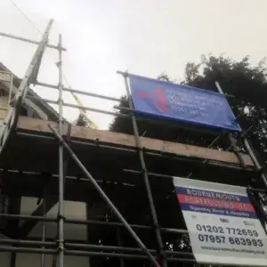 Intserv painting signage on house exterior scaffolding